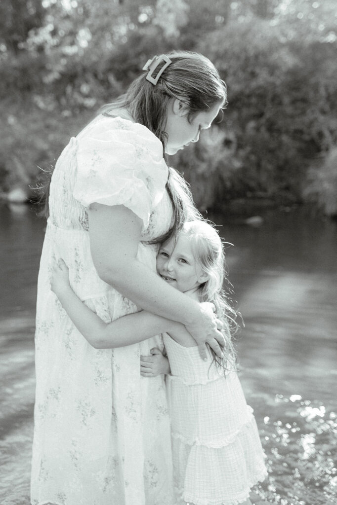 A young girl giving her mom a hug during their family photo session in Grand Forks, ND