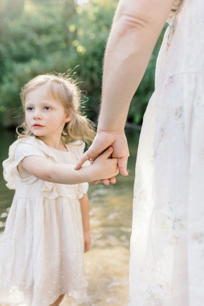 A close up of a mom and daughter holding hands during their sunset photography session at Turtle River State Park 