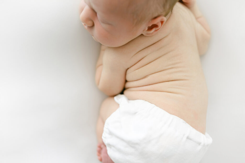 A bird's eye view of a newborn baby boy laying on his stomach during his newborn photography session.