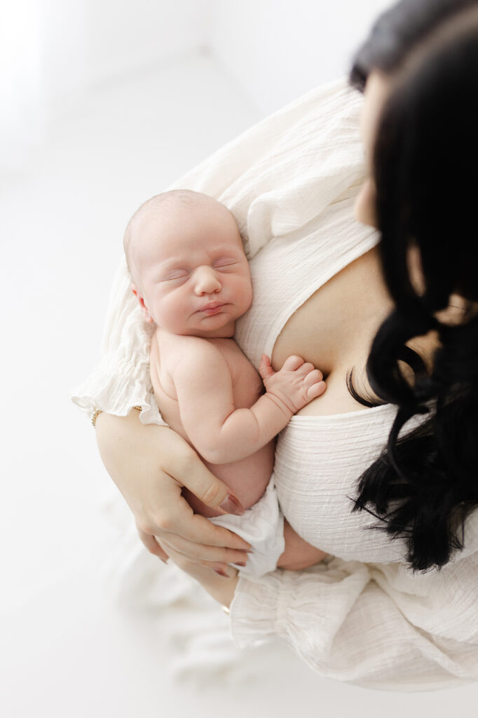 A mom holding her newborn baby during their newborn photography session in Grand Forks, ND.