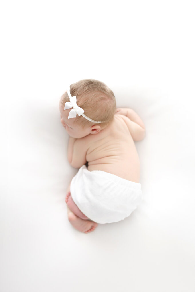 Timeless newborn photography pose with baby resting on their tummy
