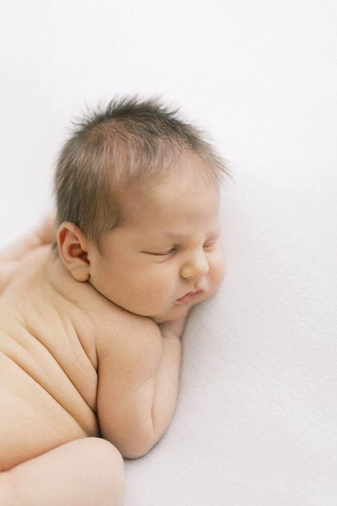 Newborn photo of baby on tummy capturing soft skin and peaceful details