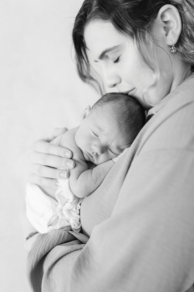 Baby sleeping on mom’s chest in a timeless newborn photo