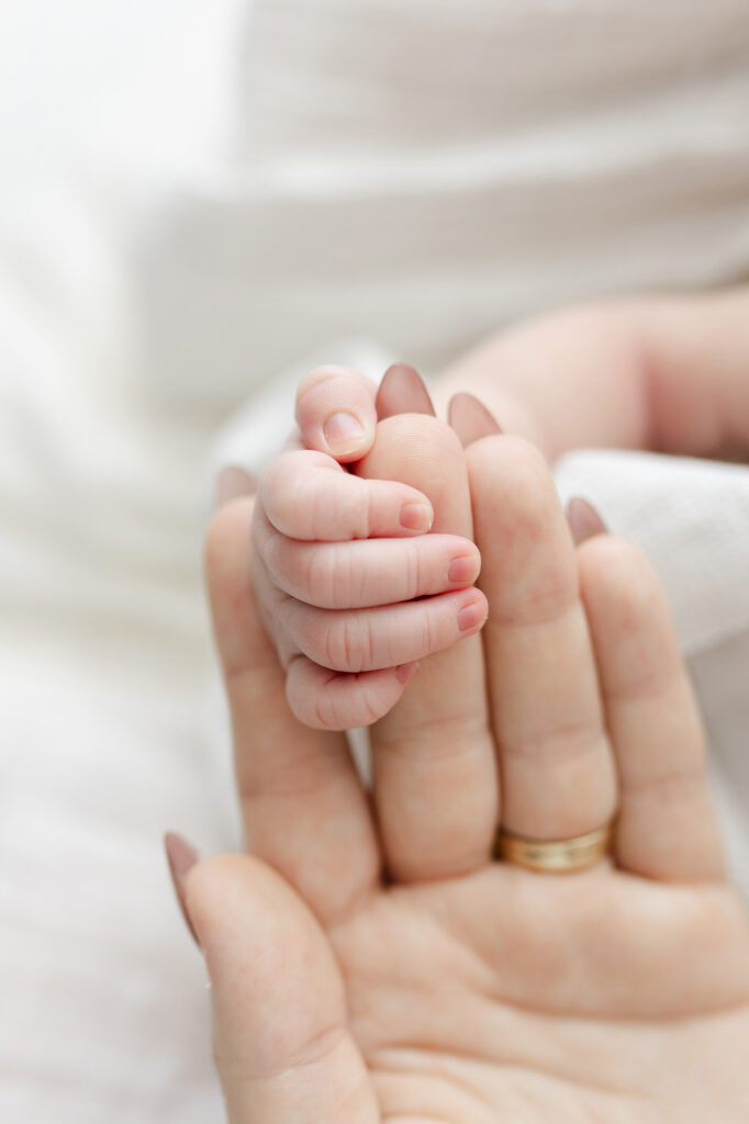 Close-up newborn photo of tiny fingers and soft skin