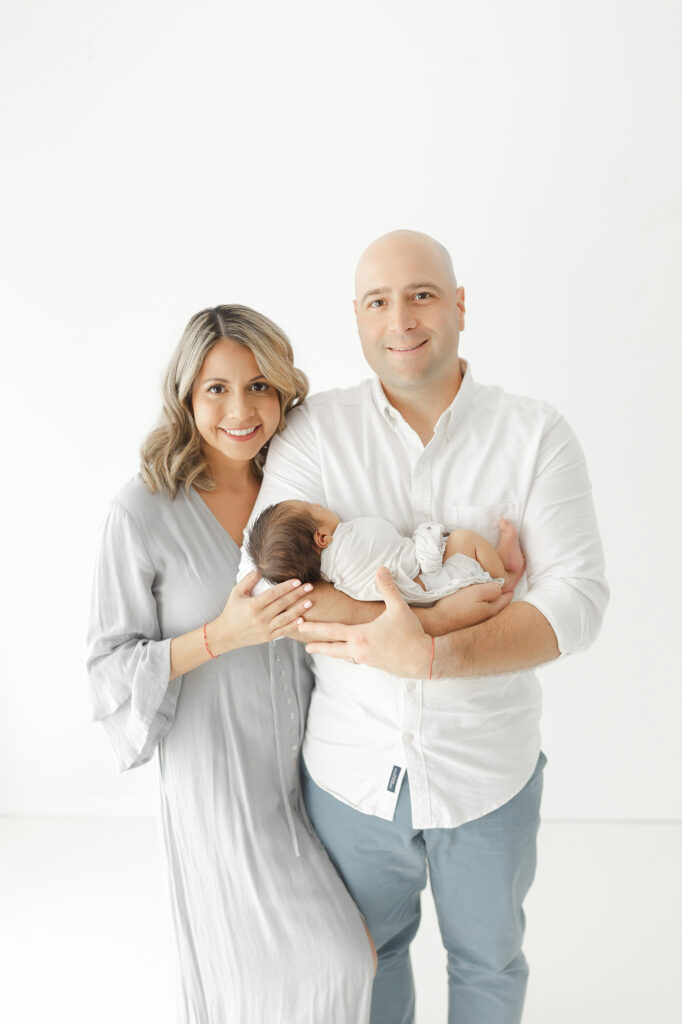 Mom and dad with newborn baby during a classic newborn photo session
